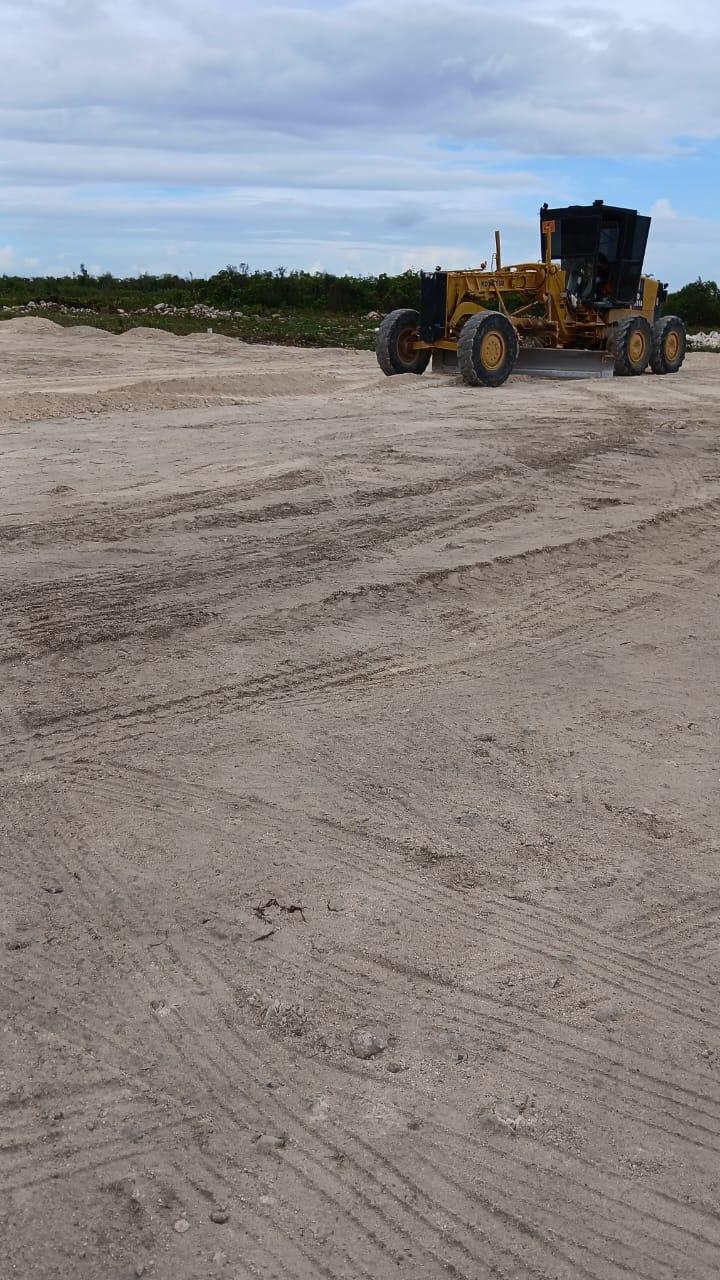 Motoniveladora nivelando un terreno arenoso